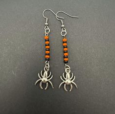 Embrace the spooky season with these Halloween dangling earrings that capture the essence of the holiday perfectly. Adorned with intricately designed spiders, each earring tells a whimsical tale of Halloween folklore. The lightweight yet eye-catching design ensures comfort while making a bold statement. Whether you're dressing up for a costume party or simply adding a touch of Halloween spirit to your ensemble, these earrings are the ideal accessory. Let these festive earrings be your playful co Halloween Hoop Earrings, Halloween Folklore, Tales Of Halloween, Festive Earrings, Gothic Earrings, Earrings Halloween, Halloween Spirit, Halloween Accessories, Beaded Accessories