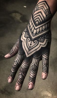 a person's hand with an intricate tattoo design on the wrist and palm area