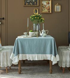 a dining room table with two chairs and a blue table cloth draped over the table