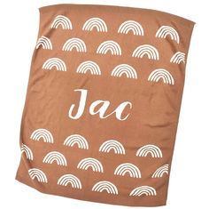 a towel with the word jac on it in white letters and rainbows, against a brown background