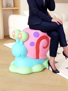 a woman sitting on top of a toy snail