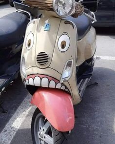 a motor scooter with a face painted on it's head and tongue