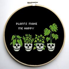 a cross stitch pattern with three skulls and plants in the middle that says, plants make me happy