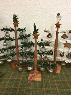 small christmas trees are lined up against the wall with ornaments around them and on top of each other