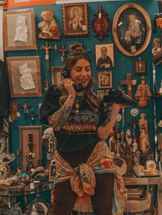 a woman sitting on top of a chair in front of a wall covered with pictures