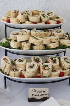 three tiered plates holding sandwiches and salads