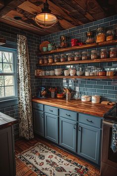 a kitchen with blue cabinets and wooden shelves on the wall, along with a rug