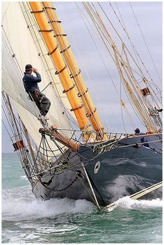 a man standing on top of a boat in the ocean