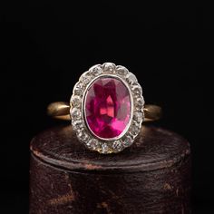 A beautiful Victorian oval cluster ring dating circa 1900, handcrafted in 18k yellow gold with a Platinum top, featuring a synthetic Ruby surrounded by 18 old cut diamonds weighing combined approx. 0.90 carat. The shoulders narrow as they meet the cluster giving a slim and elegant look to the ring. Period: Vitorian 1900s. Condition: Good condition commensurate to age. Material: 18k yellow gold, weighing 3.6 grams, acid tested. Gemstone: Oval synthetic Ruby measuring 9mm x 7mm, set in Platinum. D Victorian Ruby Ring, Antique Diamond Ring, Ruby Diamond Ring, Ruby Diamond Rings, Antique Diamond Rings, Ring Antique, Antique Diamond, Ruby Diamond, Ruby Ring