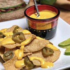 tortilla chips with jalapenos and cheese sauce on a white plate