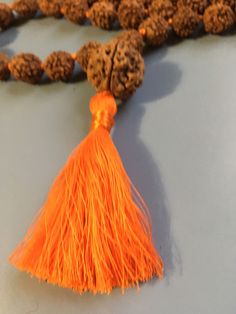 Rudraksha Mala necklace 10mm with 15mm guru bead. Hand Knotted with a cotton tassel. Hindu mala for meditation or chanting. Traditional Hand Knotted Necklaces For Festivals, Bohemian Adjustable Mala For Puja, Orange Necklace For Festivals, Adjustable Spiritual Tassel Necklace For Festivals, Handmade Mala For Meditation And Festivals, Handmade Mala For Festivals And Meditation, Spiritual Tassel Necklaces For Festivals, Spiritual Tassel Necklace With 108 Round Beads, Traditional Mala For Meditation With Latkans