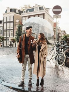 a man and woman standing under an umbrella in the rain