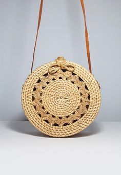 a straw bag with an intricate design on the front