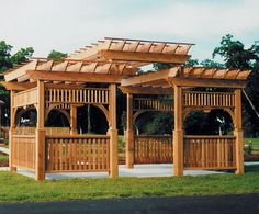 a wooden gazebo sitting on top of a lush green field