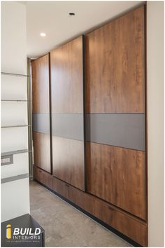 an empty room with some wooden doors and shelves on the wall in front of it