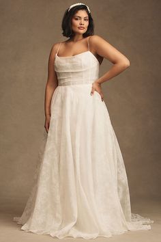 a woman in a white wedding dress posing for a photo with her hands on her hips