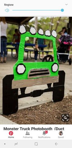 a green car made out of cardboard sitting on the ground