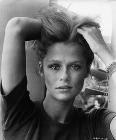 a black and white photo of a woman holding her hair