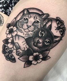 a woman's thigh with an image of two cats and flowers on the thighs