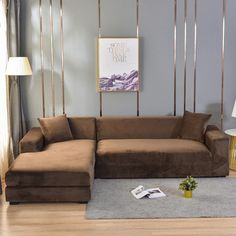 a brown couch sitting on top of a hard wood floor next to a table and lamp