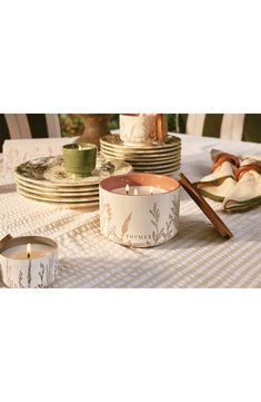 a table topped with lots of plates and candles