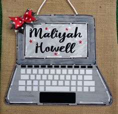 a sign that says malaysia house on the front of a laptop computer with a red bow