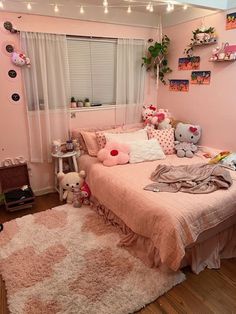 a bedroom decorated in pink and white with teddy bears on the bed, rugs and windows