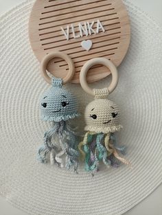 two crocheted octopus keychains on a white plate with the word jelly written above them