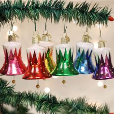 christmas bells hanging from a tree with decorations on it's branches in front of a white background