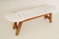 a white skateboard sitting on top of a wooden bench with holes in the bottom