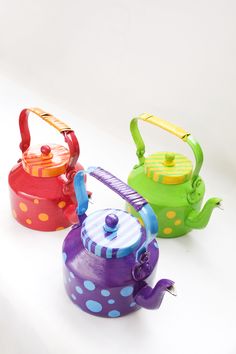 three colorful tea kettles with polka dots on them