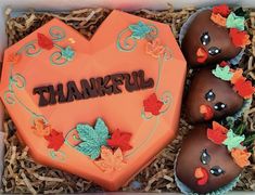 three decorated chocolates in a box with the words happy thanksgiving written on them and leaves