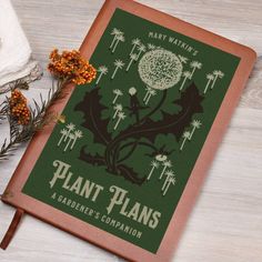 the plant plans gardener's companion book sits on a table next to some flowers