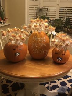 three pumpkins with flowers in them sitting on a table next to each other that say thank you for coming