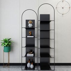 a black book shelf sitting next to a potted plant