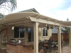 a patio covered with an awning next to a table and chairs