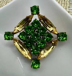 GORGEOUS GREEN! Vintage rhinestone Czech button with citrus yellow Navette and gorgeous green round stones. This one is a stunner! ONLY ONE OF THESE! DON'T MISS OUT ON THIS ONE! Has been in storage for decades. In excellent condition, new old stock. Metal shank.  Please see pic for measurements in inches.  Thank you for stopping by! Green Round Brooch Jewelry, Green Round Brooch, Green Round Brooch For Formal Occasions, Green Round Brooches For Wedding, Green Round Wedding Brooches, Elegant Green Rhinestone Brooches, Vintage Green Rhinestone Brooches, Green Vintage Rhinestone Brooches, Formal Green Rhinestone Brooches