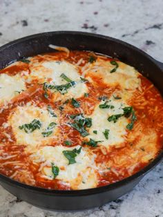 a pizza in a pan with cheese and spinach on top