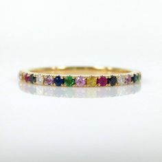 This gorgeous Eternity Band is available in your choice of 18K White, Yellow, and Rose Gold.  It features 0.55 carats of pavé set multi-colored brilliant diamonds and gemstones all the way around creating a repeating rainbow effect. The Rainbow eternity band is the perfect complement to any engagement ring or as stackable bands. Total carat weight: 0.55cts Based on ring size: 6.5 •Diamonds•Black Diamonds•Blue Sapphires•Pink Sapphires•Yellow Sapphires•Ruby•Amethyst•Tsavorites ( Green Garnets) *** Multicolor 14k Gold Jewelry For Wedding, Rainbow Multi-stone Wedding Jewelry, Multicolor Brilliant Cut Jewelry For Weddings, Rainbow Multi-stone Jewelry For Wedding, Multicolor Halo Jewelry For Wedding, Rainbow Cubic Zirconia Jewelry For Wedding, Rainbow Cubic Zirconia Wedding Jewelry, Multicolor Round Band Wedding Jewelry, Pave Wedding Bands