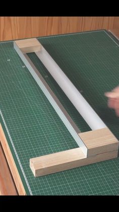 a person cutting wood with a knife on top of a green mat and wooden board