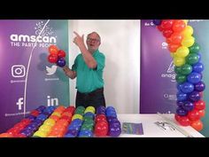 a man standing in front of a table with balloons on it and an instagram sign behind him