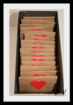 a box filled with lots of brown paper bags covered in red stencils on top of a white table