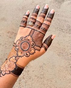 a woman's hand with henna tattoos on it