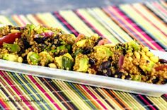 a white plate topped with food on top of a colorful table cloth next to a striped place mat