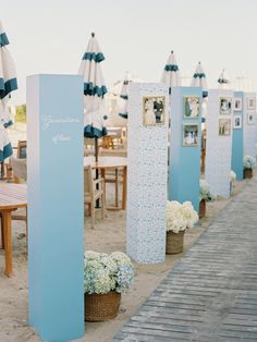 there are many blue and white umbrellas in the sand at this beachside event