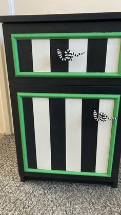 a black and white striped dresser with green trim