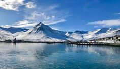 the mountains are covered in snow and blue water