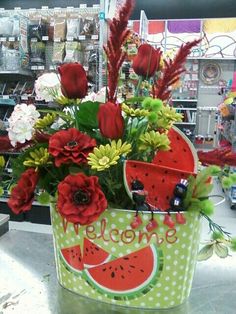 a watermelon bucket filled with flowers and greenery