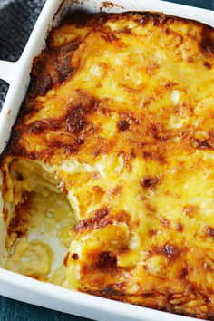 a casserole dish with cheese and meat in it on a blue table cloth