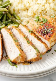 a white plate topped with chicken, rice and asparagus